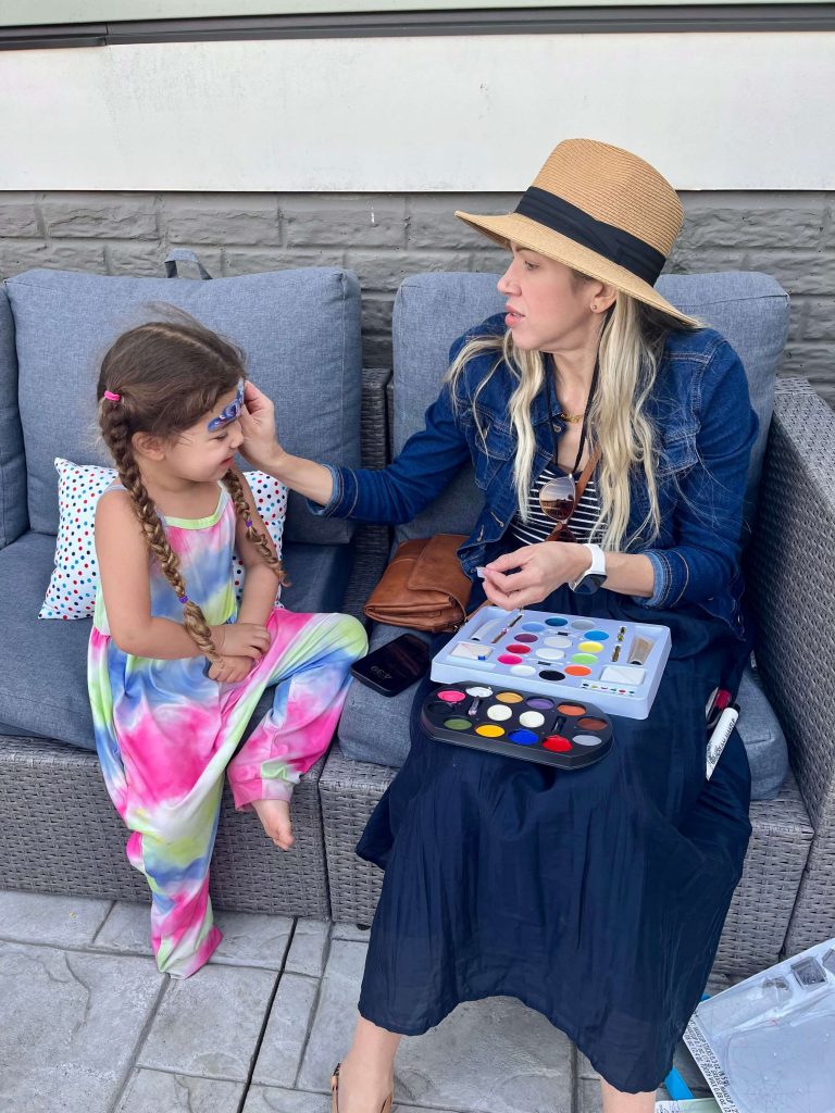 Heidi Faust painting her daughter’s face during a family activity.